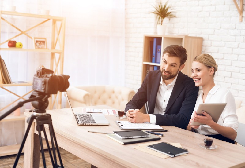 A professional video recording session with two presenters in a well-lit workspace in Denver, CO